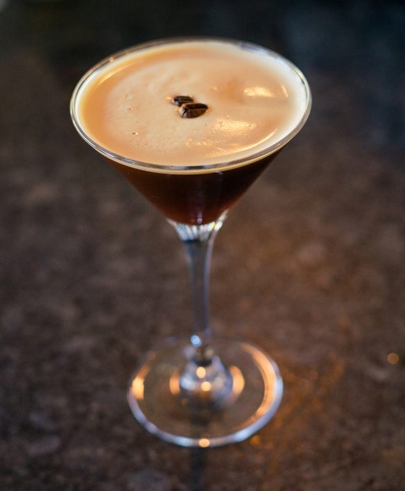 Espresso Martini mit cremigem Schaum und drei Kaffeebohnen in der klassischen Cocktailschale, serviert auf dem Steintresen der Wälderbar im Almhotel Hochhäderich.