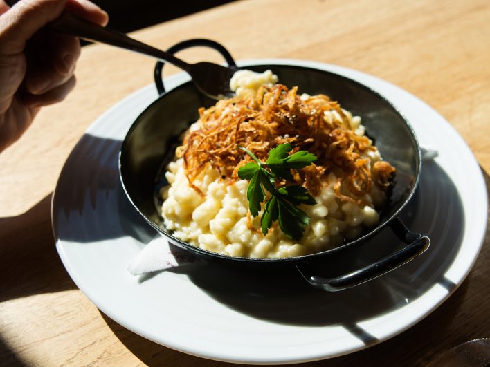 Käsespätzle mit Röstzwiebeln und Petersilie, in der Pfanne serviert im Johann & Frieda auf 1.300 Metern im Bregenzerwald.
