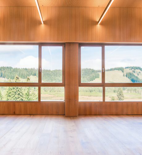 Lichtdurchfluteter Tagungsraum im Almhotel Hochhäderich mit Holzdecke und großen Panoramafenstern mit Blick über Wald und Hochmoor im Bregenzerwald