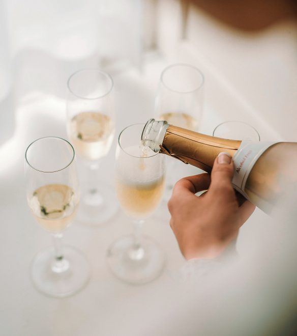 Sekt wird zum Anstoßen in mehrere Sektgläser eingeschenkt.