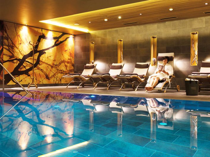 Indoor Pool und Liegen am Beckenrand.